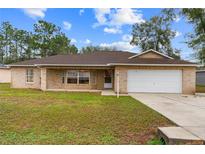 Charming one-story brick home with attached garage and well-maintained front yard at 21 Pecan Pass Ter, Ocala, FL 34472