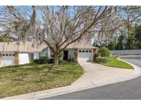 Charming single-story home featuring a well-manicured lawn, mature tree, and an attached one car garage at 2418 Se 17Th Cir, Ocala, FL 34471