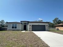 Inviting single-story home with neutral stucco, stone accents, and a spacious two-car garage at 2728 Sw 154Th Place Rd, Ocala, FL 34473