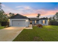 Charming single-story home with a well-manicured lawn and inviting front porch, perfect for enjoying the sunset at 3125 Sw 172Nd Lane Rd, Ocala, FL 34473