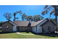 Charming single story brick home featuring manicured lawn and attractive roof line at 4534 Se 13Th St, Ocala, FL 34471