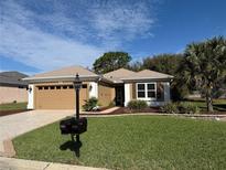 Charming single-story home with a well-manicured lawn and an attached two-car garage at 9369 Se 124Th Loop, Summerfield, FL 34491