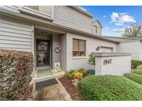 Charming front entrance of a townhouse featuring a decorative wreath and well-manicured landscaping at 1947 Se 37Th Court Cir, Ocala, FL 34471