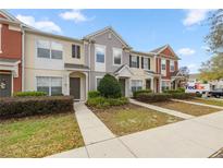 Townhomes with colorful exterior, maintained landscaping, and inviting walkways at 4491 Sw 49Th Ave, Ocala, FL 34474