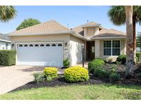Charming single-Gathering home featuring a two-car garage, mature landscaping, and a well-maintained lawn at 8669 Sw 88Th Loop, Ocala, FL 34481