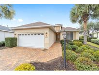 Charming single-story home with a well-manicured lawn, brick driveway, and a two-car garage at 8669 Sw 88Th Loop, Ocala, FL 34481