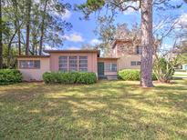 Charming home with a well-manicured lawn and mature trees providing shade at 1022 Ne 11Th Ave, Ocala, FL 34470