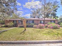 Charming single-story home with a well-maintained front yard and blooming azalea bushes at 1034 Ne 11Th St, Ocala, FL 34470