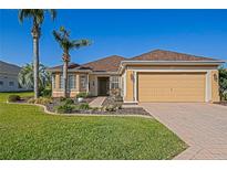 Charming single-story home featuring a manicured lawn and a two-car garage at 13128 Se 97Th Terrace Rd, Summerfield, FL 34491