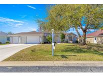 Charming single-story home with a three-car garage, mature landscaping, and a well-maintained lawn at 1956 Nw 50Th Cir, Ocala, FL 34482