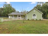Charming single-story home with a covered front porch and lovely green lawn at 20280 Sw 69Th Pl, Dunnellon, FL 34431