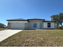 Modern home with white facade, stone accents, and a two-car garage on a sunny day at 2602 Sw 154Th Ln, Ocala, FL 34473