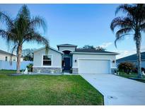 Charming single-story home featuring well-manicured lawn, gray exterior, and a two-car garage at 4241 Sw 62Nd Loop, Ocala, FL 34474