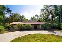 Charming single-story home featuring a red tiled roof, circular driveway, and mature landscaping at 4301 Se 6 Ave, Ocala, FL 34480