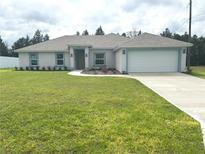 Charming single-story home featuring a well-manicured lawn, two-car garage, and complementary blue trim at 5646 Sw 129Th Place Rd, Ocala, FL 34473