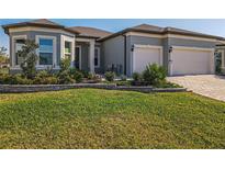 Charming home featuring lush lawn, stone-lined flowerbeds, and a two-car garage at 8843 Sw 57Th Place Rd, Ocala, FL 34481