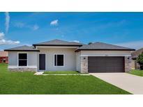 New construction home features stone accents, dark garage door, neutral paint, and green grass at 3085 Sw 131St Place Rd, Ocala, FL 34473