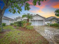 Charming single-story home with lush landscaping and a brick-paved driveway creating great curb appeal at 3785 Avon Ct, Clermont, FL 34711