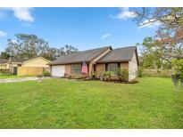 Charming single-story home with a well-maintained lawn and colorful landscaping at 1000 Woodward Oaks Cir, Eustis, FL 32726