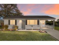 Charming single-story home featuring a covered carport and well-manicured front lawn at 10495 Sw 100Th Ave, Ocala, FL 34481