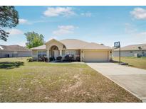 Charming single-story home featuring a two-car garage and well-maintained front lawn at 17 Pine Course Loop, Ocala, FL 34472