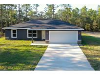 Charming single-story home featuring a two-car garage, well-manicured lawn, and inviting neutral paint scheme at 17710 Sw 48Th Sw Pl, Dunnellon, FL 34432