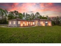 Charming single-story home with well-manicured lawn and beautiful landscape under a colorful sunset sky at 4869 Nw 101St Street Rd, Ocala, FL 34482