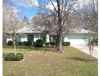 Charming single-story home with a well-manicured lawn and mature trees creating a welcoming curb appeal at 5181 Sw 164Th Street Rd, Ocala, FL 34473