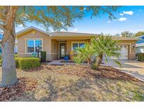Charming single-story home featuring a well-manicured front yard with mature trees and landscaping at 9841 Sw 95Th Loop, Ocala, FL 34481