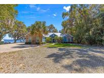 Charming waterfront home with a lush lawn and mature landscaping at 12336 E Highway 25, Ocklawaha, FL 32179
