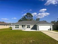Charming single-story home with well-maintained lawn and a two-car garage at 15055 Se 93Rd Ct, Summerfield, FL 34491