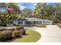 Charming single-story home with a manicured lawn, circular driveway, and an inviting front porch perfect for relaxation at 8380 Se 7Th Avenue Rd, Ocala, FL 34480