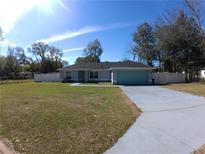 Charming one-story home with a lush lawn, mature trees, and a two-car garage at 8890 Sw 33Rd Ct, Ocala, FL 34476