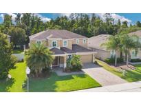 Charming two-story home with a well-maintained lawn, brick driveway, and lush landscaping at 1073 Vinsetta Cir, Winter Garden, FL 34787