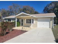 Charming single-story home with a welcoming front porch and attached one-car garage with a long driveway at 11255 Sw 76Th Ter, Ocala, FL 34476
