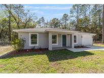 Beautiful single-story home with modern paint, landscaped yard, and one car garage at 13396 Sw 105 Pl, Dunnellon, FL 34432