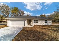 Charming single-story home with a two-car garage and a well-manicured front yard at 13495 Sw 114Th Ln, Dunnellon, FL 34432