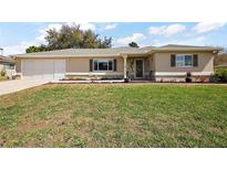 Charming single-story home featuring a well-maintained lawn and inviting curb appeal at 13751 Se 88Th Ct, Summerfield, FL 34491