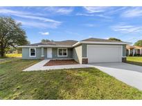 Charming single-story home with a two-car garage, freshly landscaped front yard, and modern architectural details at 20764 Sw Starling Dr, Dunnellon, FL 34431