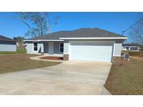 Charming single-story home featuring a well-maintained lawn and a two-car garage at 27 Laurel Ct, Ocala, FL 34472
