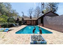 Scenic backyard pool, featuring patio area with sculptures and greenery, providing a tranquil outdoor space at 411 Sw 38Th St, Ocala, FL 34471