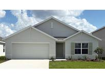 Charming single-story home with a two-car garage, manicured lawn, and light green front door at 4770 Sw 88Th Ln, Ocala, FL 34476