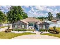 Charming single-story home with custom wood accents, lush landscaping, and a welcoming front porch at 6125 Se 11Th St, Ocala, FL 34472