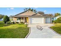 Charming single-Gathering home boasting a well-manicured lawn and a two-car garage at 1004 Parker Pl, Lady Lake, FL 32159