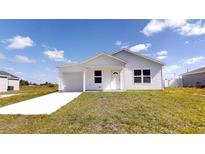 Charming single-story home with a well-manicured lawn, garage, and a classic front door at 13627 Sw 103Rd Pl, Dunnellon, FL 34432