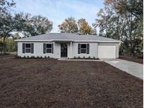 Charming single-story home with a gray exterior, black shutters and a well-maintained front yard at 261 Locust Pass Loop, Ocala, FL 34472