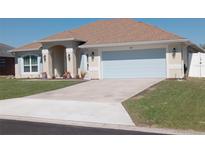 Inviting single-story home featuring an attached two-car garage, manicured lawn and a charming arched entryway at 3819 Se 99Th St, Belleview, FL 34420