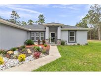 Charming home exterior with a well-manicured lawn, rock landscaping and a welcoming front entrance at 5620 Sw 172Nd Loop, Ocala, FL 34473