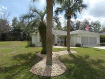 Charming single-story home with well-manicured lawn and attractive landscaping featuring decorative stones at 9610 Sw 198Th Cir, Dunnellon, FL 34432