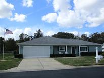 Charming single-story home boasts a well-manicured lawn and an attached two-car garage at 11792 Sw 137Th Loop, Dunnellon, FL 34432